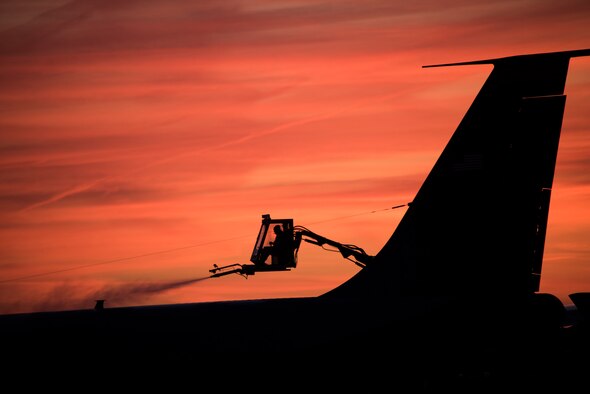 Tech. Sgt. de-ices an aircraft early in the morning