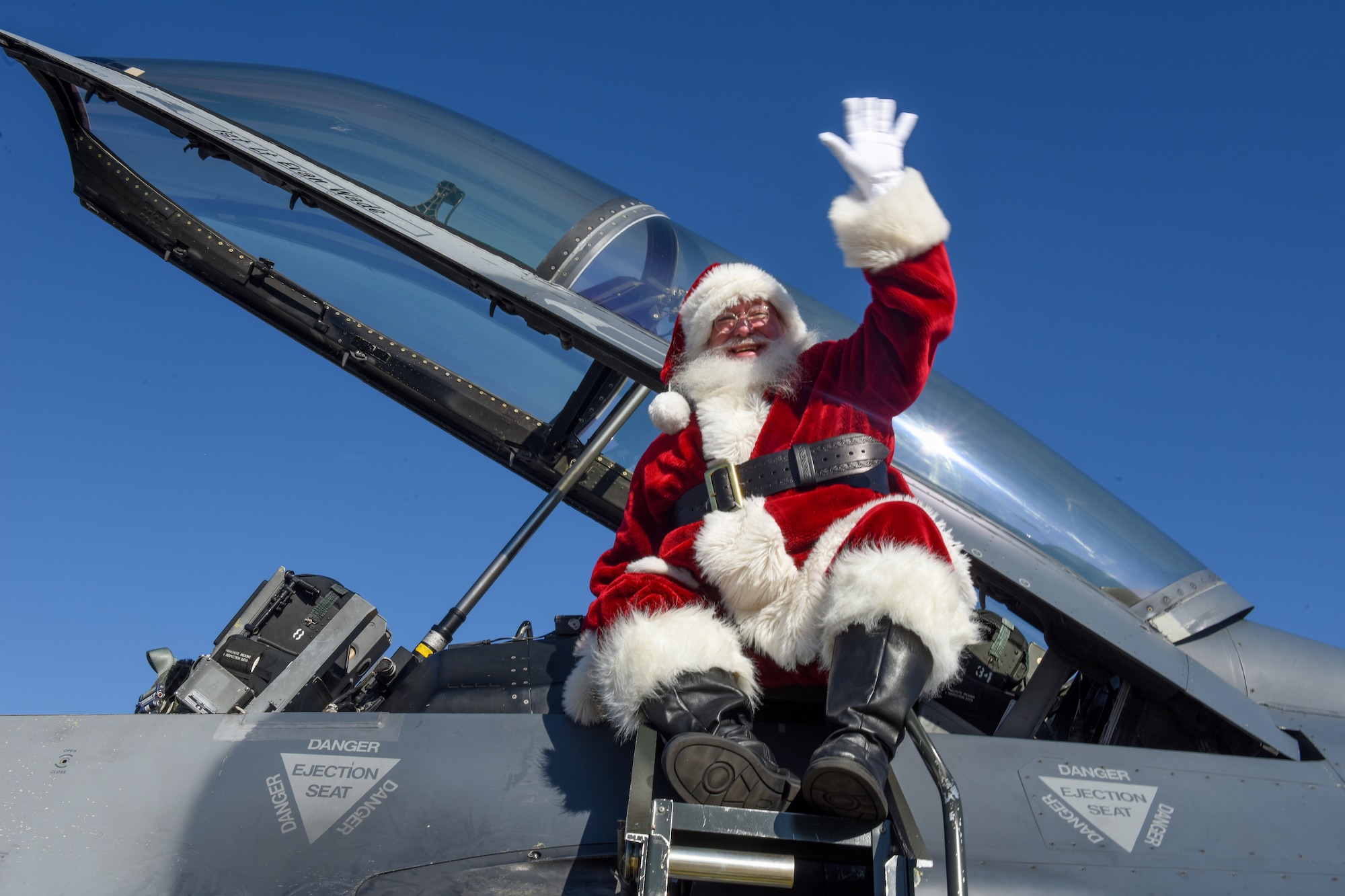Santa Claus waves as he arrives in an F-16 Fighting Falcon