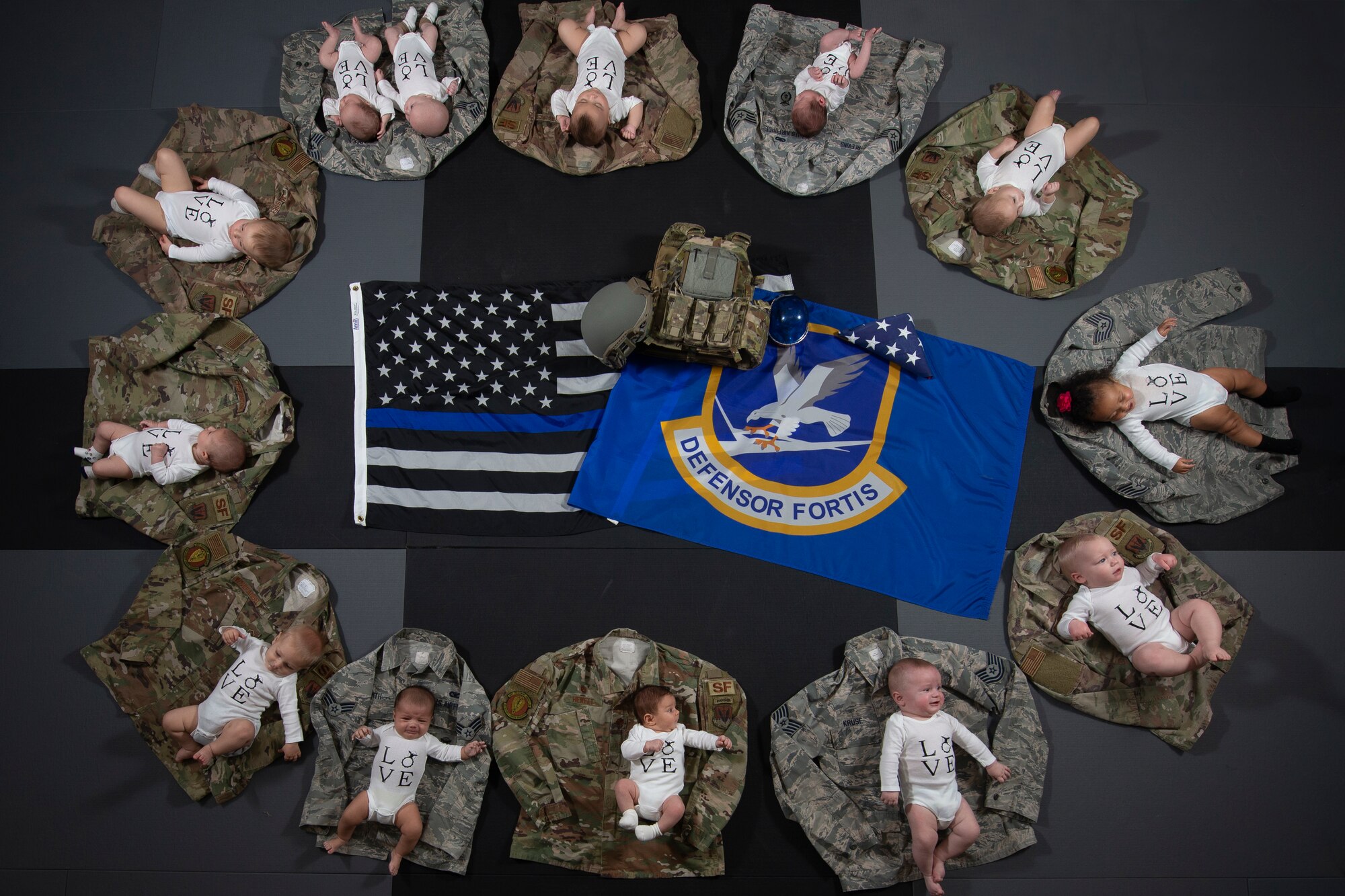 Thirteen babies lay on their parents uniforms Nov. 20, 2019, at Mountain Home Air Force Base, Idaho. The U.S. Air Force has annouced 2019 as the Year of the Defender in honor of security forces members. (U.S. Air Force photo by Airman Natalie Rubenak)