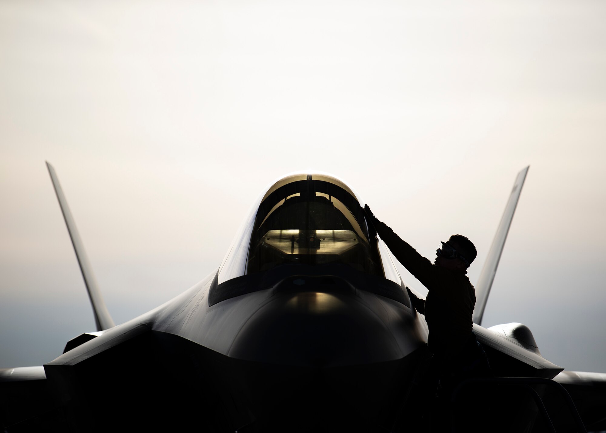 An Airman cleans the canopy of an F-35A Lighting II fighter jet.