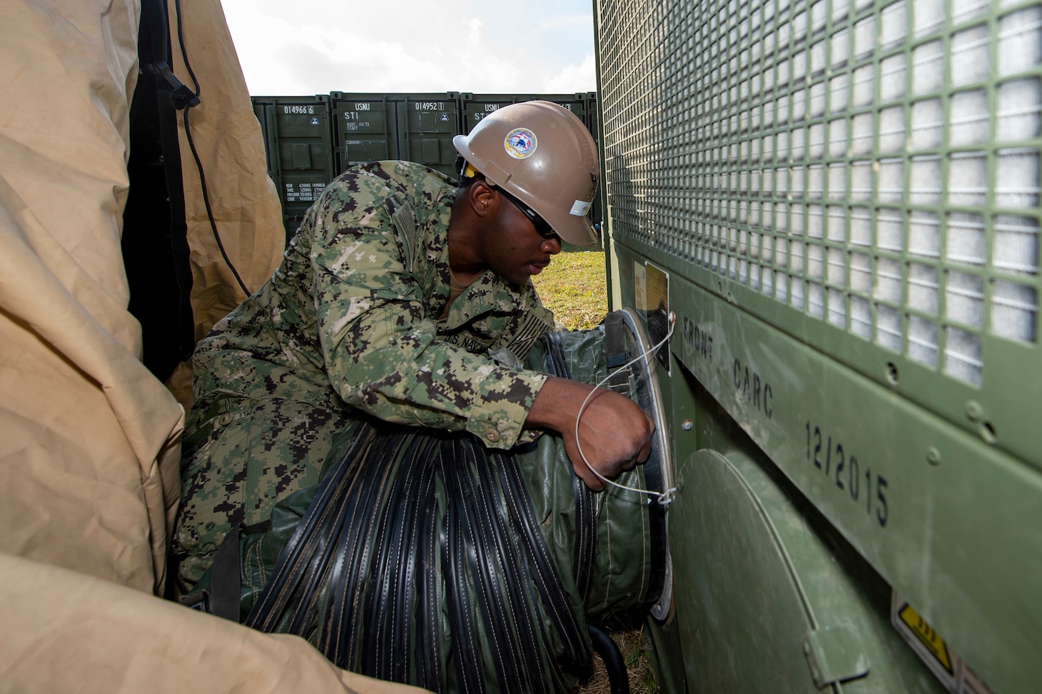 OKINAWA, Japan (Dec. 16, 2019) Builder 2nd Class Javaughn Reid, deployed with Naval Mobile Construction Battalion (NMCB) 5, sets up air conditioning in one of the communication tents during a joint Communication Exercise (COMMEX) and 48-hour Mount-Out Exercise (MOX) on board Camp Shields, Okinawa. Combining COMMEX and MOX demonstrates the battalion’s ability to rapidly deploy and operate in a tactical environment. NMCB-5 is deployed across the Indo-Pacific region conducting high-quality construction to support U.S. and partner nations to strengthen partnerships, deter aggression, and enable expeditionary logistics and naval power projection.