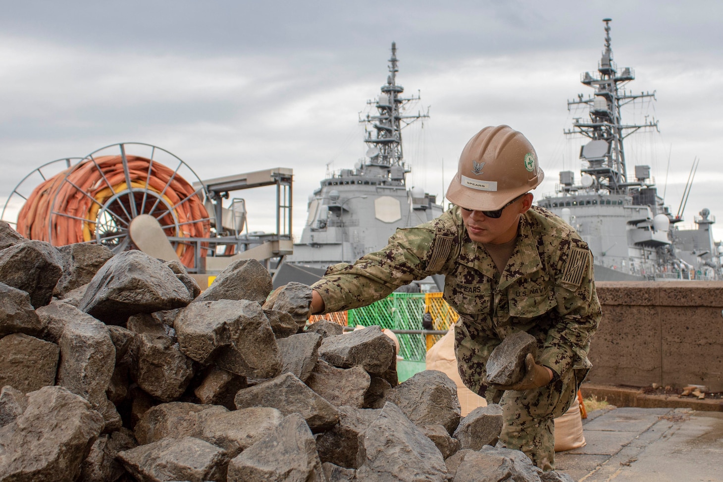 SASEBO, Japan (Oct. 28, 2019) Builder 1st Class Remie Acosta, from Lawrence, Massachusetts, and Utilitiesman 3rd Class Jaime Orobio, from Houston, both deployed with Naval Mobile Construction Battalion (NMCB) 5’s Detail Sasebo, place riprap as part of the repairs underway for a section of the seawall on Commander Fleet Activities Sasebo to further improve the base’s military readiness and capability. Seabees at Detail Sasebo are currently repairing a typhoon damaged the seawall to mitigate further erosion and destabilization of the adjacent Pre-Engineered Building Foundation. NMCB-5 is deployed across the Indo-Pacific region conducting high-quality construction to support U.S. and partner nations to strengthen partnerships, deter aggression, and enable expeditionary logistics and naval power projection.