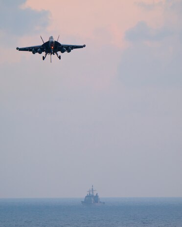 191220-N-WR846-0151 NORTH ARABIAN SEA (Dec. 20, 2019) An EA-18G Growler, attached to the "Rooks" of Electronic Attack Squadron (VAQ) 137, approaches the flight deck of the aircraft carrier USS Harry S. Truman (CVN 75) as the guided-missile cruiser USS Normandy (CG 60) transits nearby in the Arabian Sea, Dec. 20, 2019. The Harry S. Truman Carrier Strike Group is deployed to the U.S. 5th Fleet area of operations in support of naval operations to ensure maritime stability and security in the Central Region, connecting the Mediterranean and the Pacific through the western Indian Ocean and three strategic choke points. (U.S. Navy photo by Mass Communication Specialist 2nd Class Jake Carrillo)