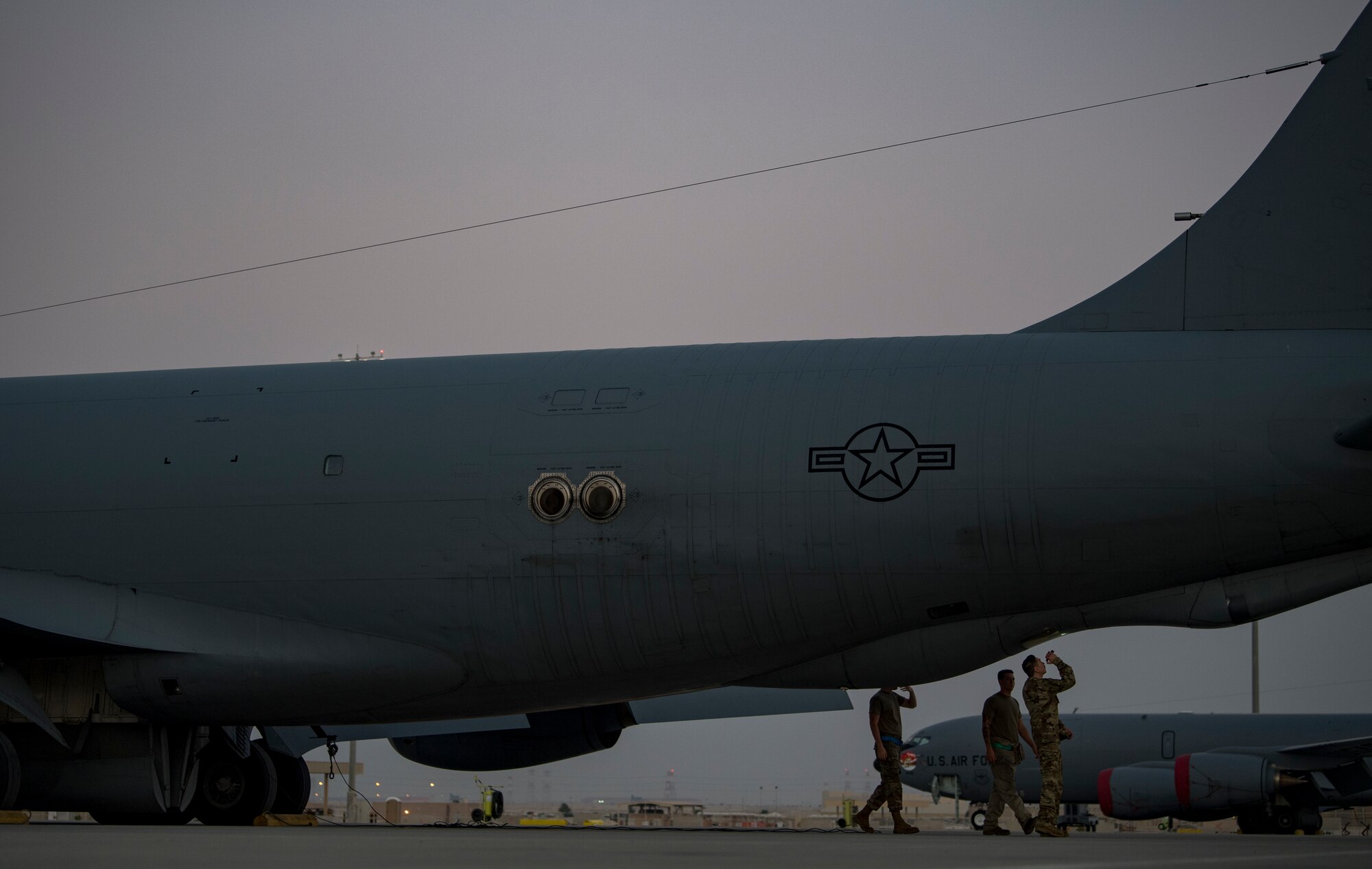 A U.S. Air Force KC-135 Stratotanker pilot and two crew chiefs with the 28th Expeditionary Air Refueling Squadron conduct a preflight inspection at Al Udeid Air Base, Qatar, Dec. 6, 2019.