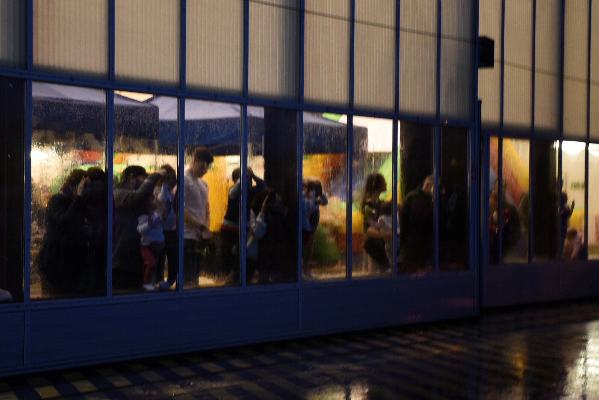 Families gather at the windows of a dual bay hanger with hopes to see Santa's arrival on a C-130J Hercules aircraft during the Rudolph the Red Nosed Herc event at Ramstein Air Base, Germany, Dec. 20, 2019.