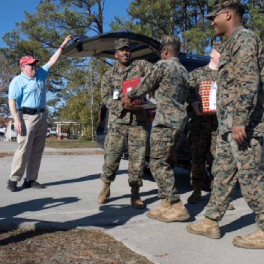 U.S. Marine Corps MSgt. Lavoris Beamon, the community plans advisor assigned to Marine Corps Air Station (MCAS) Cherry Point, hands off boxes of baked goods to Marines during the annual cookie drop event at MCAS Cherry Point, North Carolina, Dec. 16, 2019. The cookie drop organized by Carteret County’s Chamber of Commerce’s Military Affairs Committee, donates baked goods to the Marines and Sailors on duty at the air station. Elementary school students from Carteret County made unique Christmas cards in the boxes to wish the service members a happy holiday season. (U.S. Marine Corps photo by Cpl. Micha Pierce)
