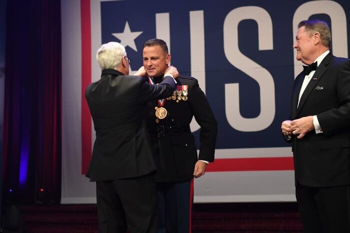 USO representatives award U.S. Marine Corps Capt. Richard A. Hayek, the 12th Marine Corps District adjutant, with the George Van Cleave Military Leadership Award during the 58th USO Armed Forces Gala and Gold Medal Dinner in New York, New York, Dec. 4.