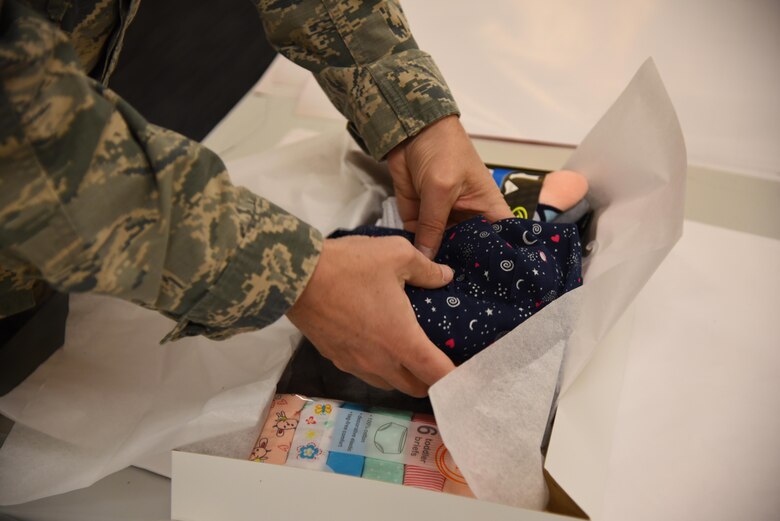 Col. Gary Hayward, 14th Mission Support Group commander, places a shirt into a box to be wrapped Dec. 19, 2019, on Columbus Air Force Base, Miss. Airmen, spouses, and community members of Columbus came together at the Columbus Club to volunteer and show their support for the Happy Irby Holiday Wrap. (U.S. Air Force photo by Airman 1st Class Jake Jacobsen)