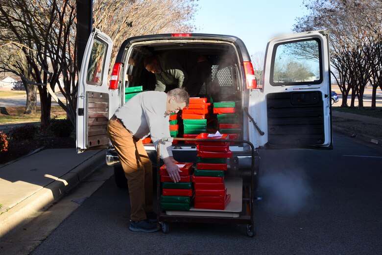 George Irby, chief executive officer of the Happy Irby Fund, and Bruce Hanson, member of the Happy Irby Fund Board, place the finished wrapped gifts in a van to be transported to schools Dec. 19, 2019, on Columbus Air Force Base, Miss. The program was founded by the late George “Happy” Irby, long-term staff member at the Columbus Club in the 1950s and is continued by his son, George Irby. (U.S. Air Force photo by Airman 1st Class Jake Jacobsen)