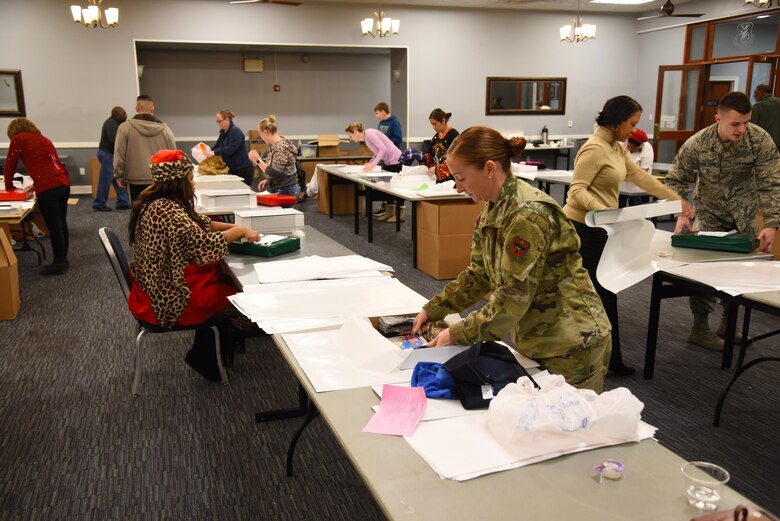 Maj. Randi Ludington, 14th Comptroller Squadron commander, places items into boxes at the Columbus Club Dec. 19, 2019, on Columbus Air Force Base, Miss. Presents are bought from local businesses and then brought to the base to be wrapped by volunteers. (U.S. Air Force photo by Airman 1st Class Jake Jacobsen)