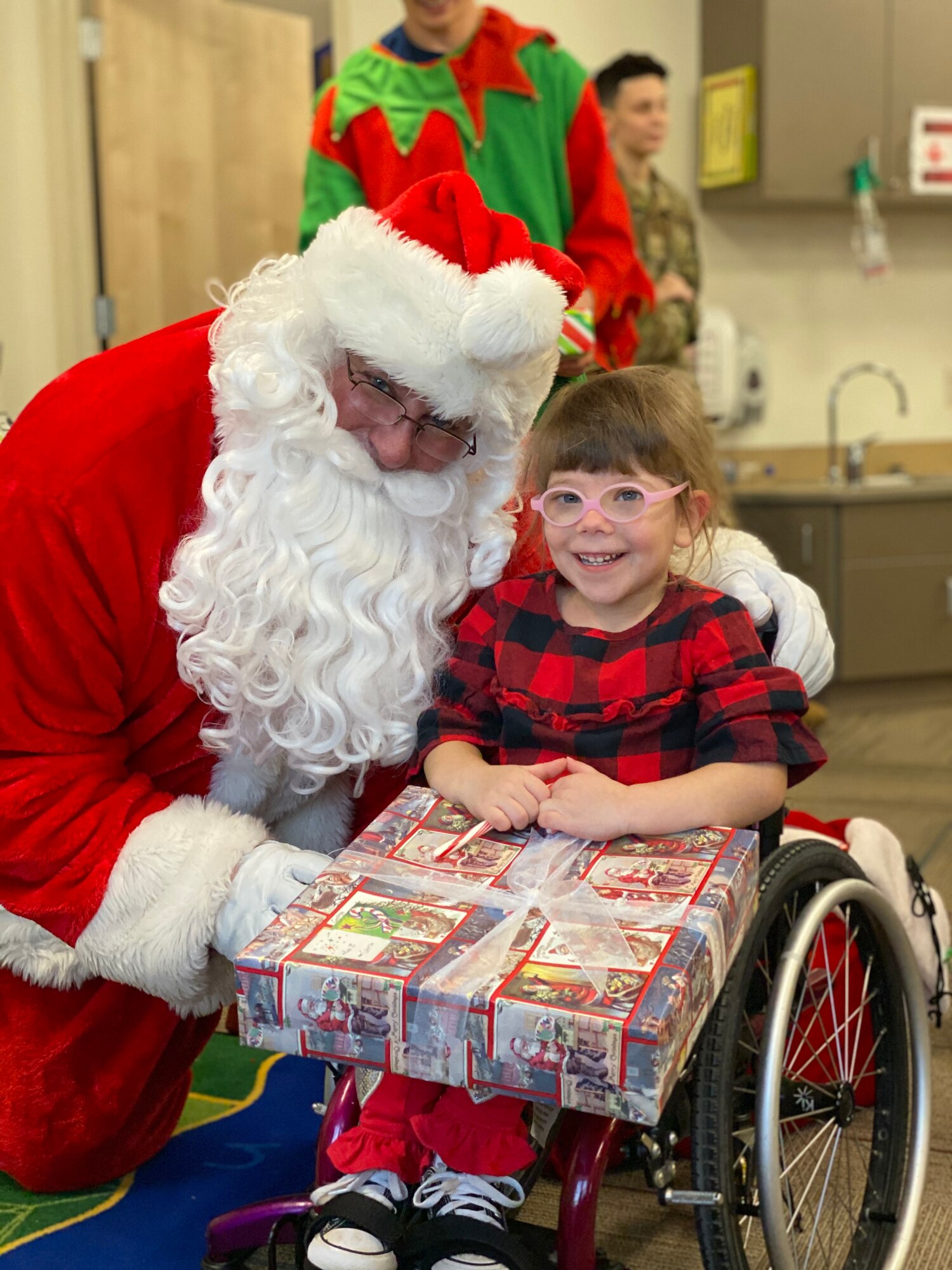 Santa poses with a child enrolled at the Youth & Family Services Center in Rapid City, S.D., Dec.17, 2019. For the past 12 years, Dave Garrett, 28th Operations Support Squadron Assistant Director of Operations, has posed as Santa, visiting the kids at the YFS Center during the 28th Operations Group’s annual Angel Tree event. (U.S. Air Force photo by Senior Airman Michael Jones)