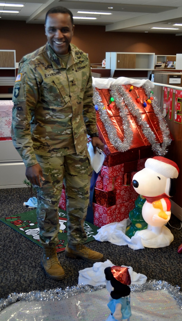 DLA Troop Support Commander Army Brig. Gen. Gavin Lawrence inspects the Peanuts-inspired display created by the Business Process Support office for a holiday decorating contest Dec. 20, 2019, in Philadelphia.