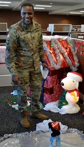 DLA Troop Support Commander Army Brig. Gen. Gavin Lawrence inspects the Peanuts-inspired display created by the Business Process Support office for a holiday decorating contest Dec. 20, 2019, in Philadelphia.