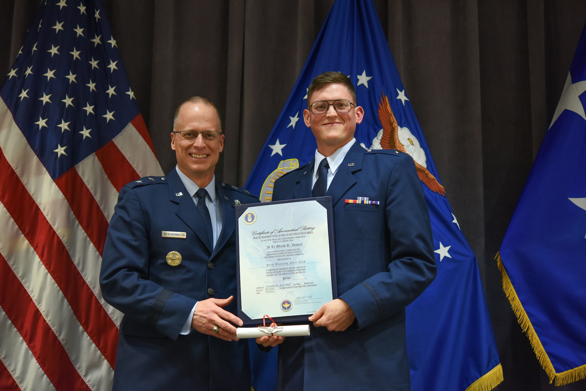 Maj. Gen. Mark Weatherington, Air Education and Training Command deputy commander, presents 2nd Lt. Micah Daniel with his pilot’s wings during a dual commissioning and “winging” ceremony Dec. 19, 2019, at Maxwell Air Force Base, Alabama. Daniel made history as one of the first prior-enlisted Airmen to receive pilot’s wings at the same time as his lieutenant’s bars. (U.S. Air Force photo by Staff Sgt. Quay Drawdy)