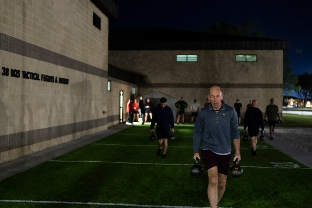 A photo of an Airman carrying kettlebells