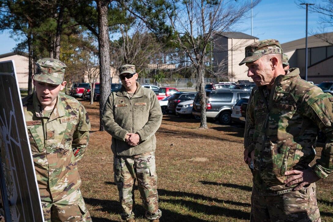 A photo of an Airman explains a construction plan