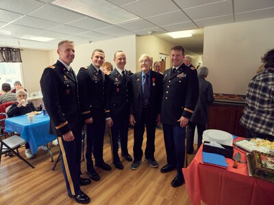 World War II veteran Charlie Brown stands with current and former members of the New York Army National Guard's 1st Battalion, 258th Field Artillery Regiment, after being presented the French Legion of Honor during a ceremony in Olean, N.Y., Dec. 20, 2019.
