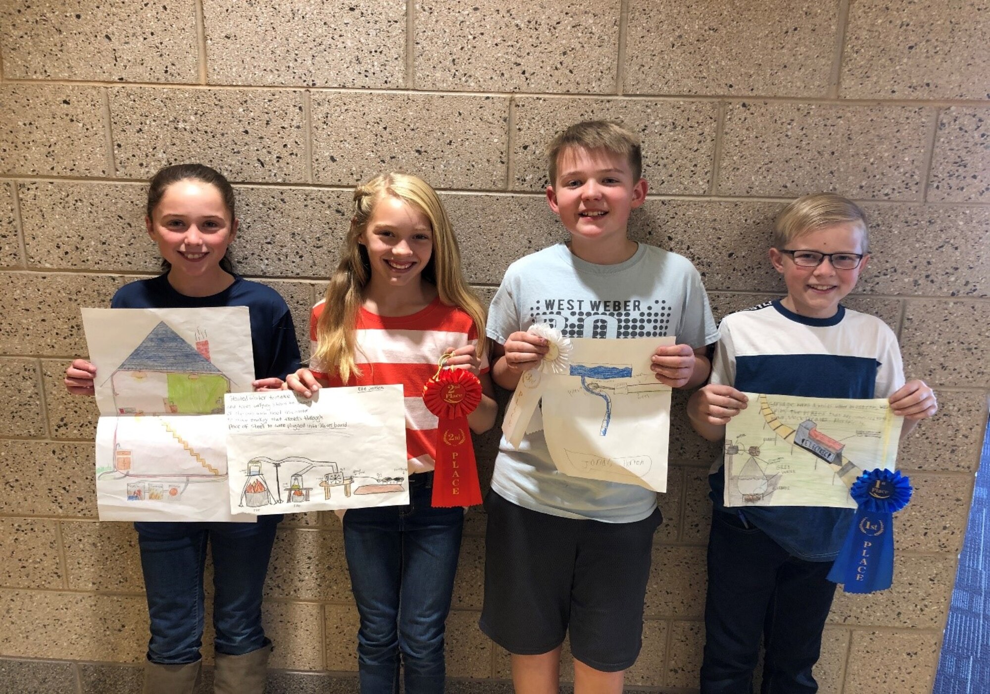 Four 6th graders from est Weber Elementary hold up their winning Energy Action Month Art Contest drawings.