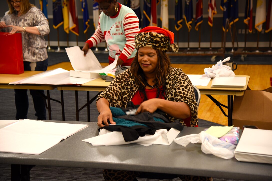 Lakezia Ham, an accountant with the 14th Comptroller Squadron, folds a sweatshirt to be wrapped at the Columbus Club Dec. 19, 2019, on Columbus Air Force Base, Miss. The Happy Irby Christmas Fund is a non-profit private organization that has benefited thousands of adults and children alike by providing clothing, supplies and fruit baskets. (U.S. Air Force photo by Airman 1st Class Jake Jacobsen)