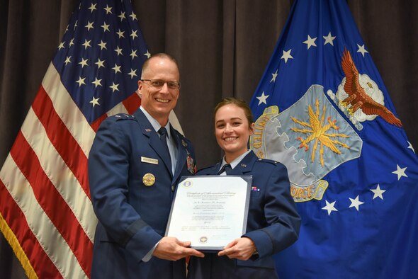 Maj. Gen. Mark Weatherington, Air Education and Training Command deputy commander, presents 2nd Lt. Kristen Savage with her pilot’s wings during a dual commissioning and “winging” ceremony Dec. 19, 2019, at Maxwell Air Force Base, Alabama. Savage was a student pilot who graduated PTN version 2, an Air Education and Training Command program to explore what is possible in training with the use of innovative technology and how it can be applied to not only pilot training but also to training across AETC.  She earned her wings, but couldn’t wear them until she commissioned. (U.S. Air Force photo by Staff Sgt. Quay Drawdy)