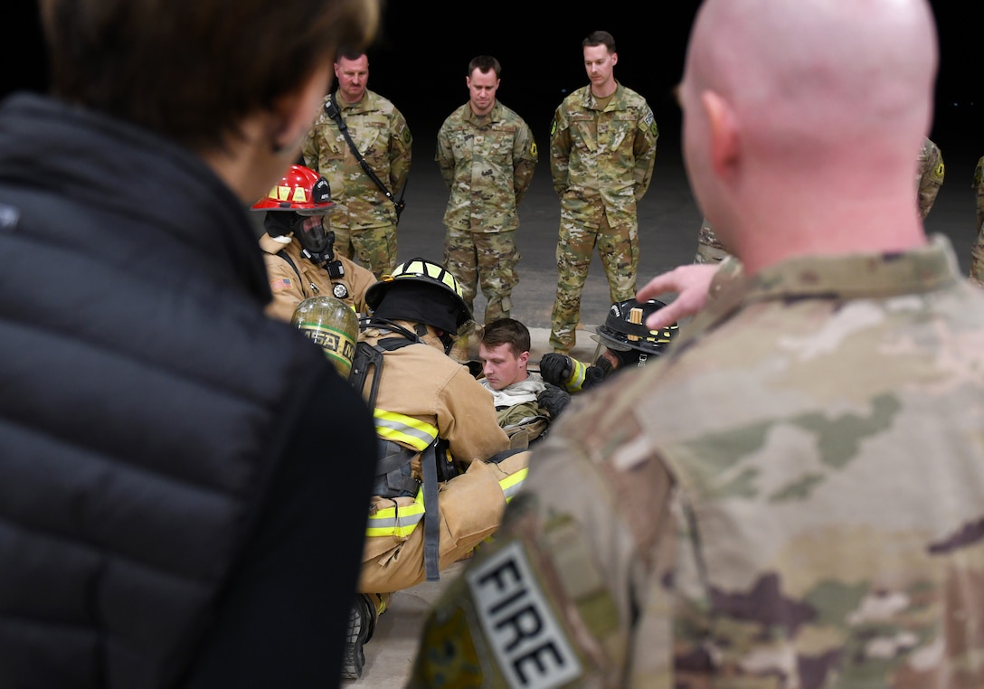Secretary of the Air Force Barbara M. Barrett watches 724th Expeditionary Air Base Squadron firefighters demonstrate their tactics for rescuing a downed team member during her visit to Nigerien Air Base 201, Niger, Dec. 21, 2019. While at the installation, Barrett learned how each unit supports the mission from building the future of the base to defending its assets and personnel. (U.S. Air Force photo by Staff Sgt. Alex Fox Echols III)