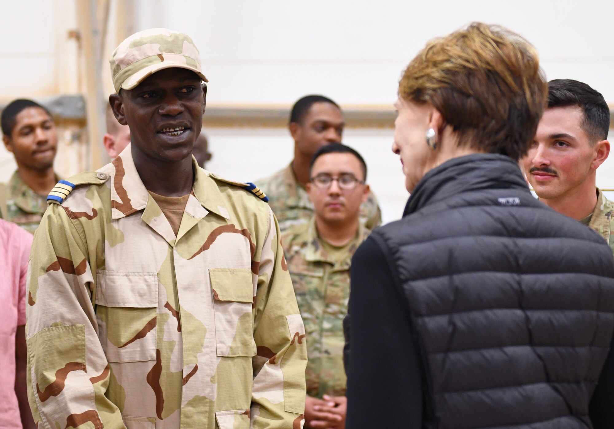 A member of the Forces Armées Nigeriennes (Nigerien Armed Forces) talks with Secretary of the Air Force Barbara M. Barrett during her visit to Nigerien Air Base 201, Niger, Dec. 21, 2019. Members of the 409th Expeditionary Security Forces Squadron and FAN work together through their cooperative partnership to vigilantly secure and defend the base. (U.S. Air Force photo by Staff Sgt. Alex Fox Echols III)