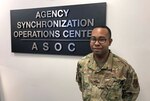 Military officer stands in front of a sign