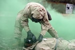 While training during a simulated Chemical, Biological, Radiological, and Nuclear, or CBRN, attack at Joint Base San Antonio-Camp Bullis, a Soldier checks a causality's Mission Oriented Protective Posture, or MOPP, mask.
