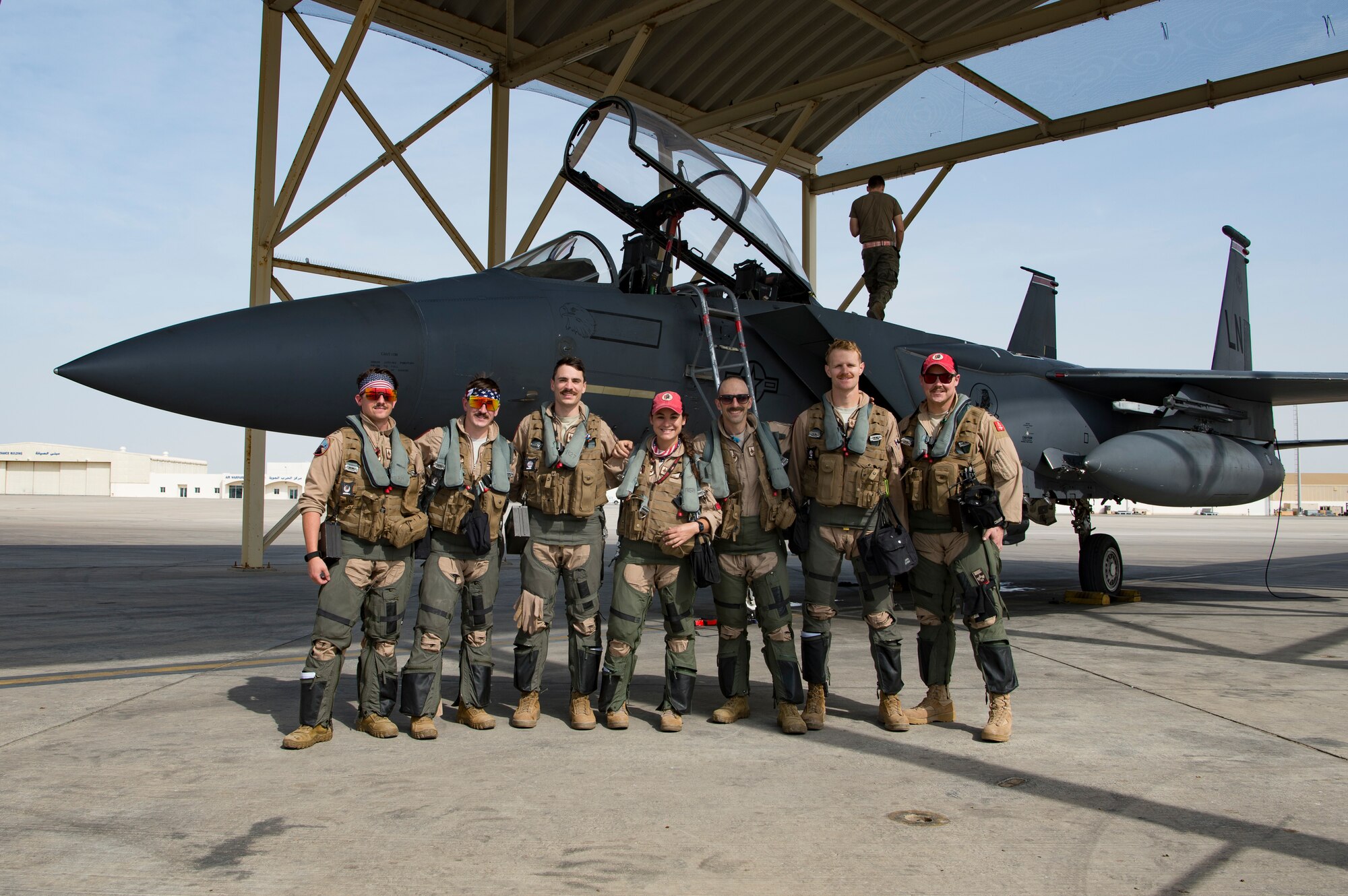 Aircrew with the 494th Expeditionary Fighter Squadron pose for a photo in front of an F-15E Strike Eagle, Al Dhafra Air Base, United Arab Emirates, after conducting a fly-by honoring Qatar National Day, Dec. 18, 2019.