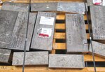 Various-sized bars of titanium sit on a pallet awaiting shipment.