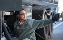 An gives a thumbs up while working on a refueling truck.
