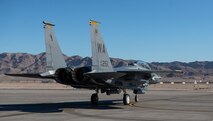 An F-15E Strike Eagle fighter jet taxis on the flight line.