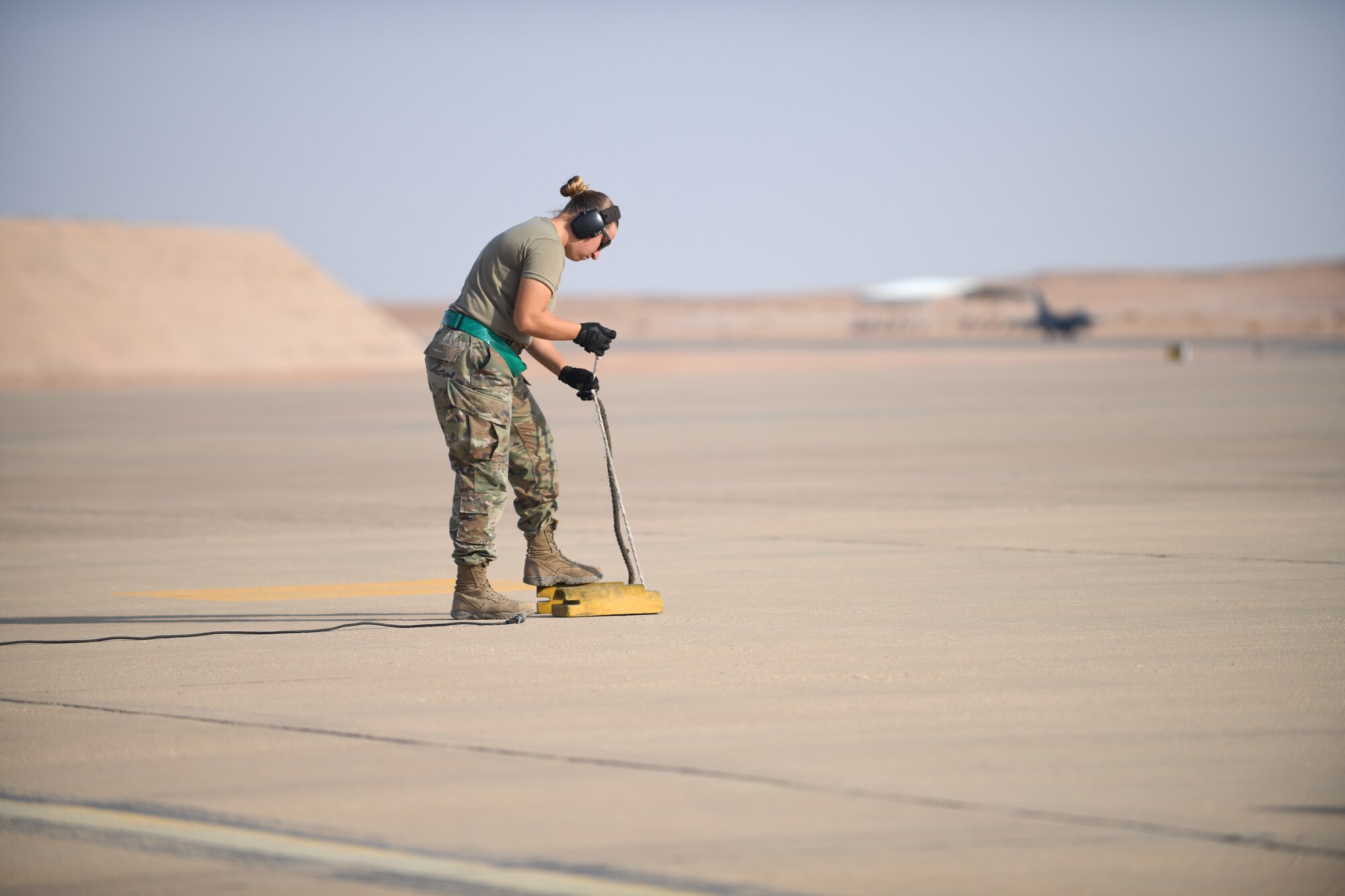 U.S. Air Force Senior Airman Eleanor Lapi, 555th Expeditionary Aircraft Maintenance Unit weapons load crew member, prepares aircraft wheel chocks for the arrival of an F-16 Fighting Falcon, assigned to the 555th Expeditionary Fighter Squadron, Dec. 2, 2019 at Prince Sultan Air Base, Saudi Arabia.
