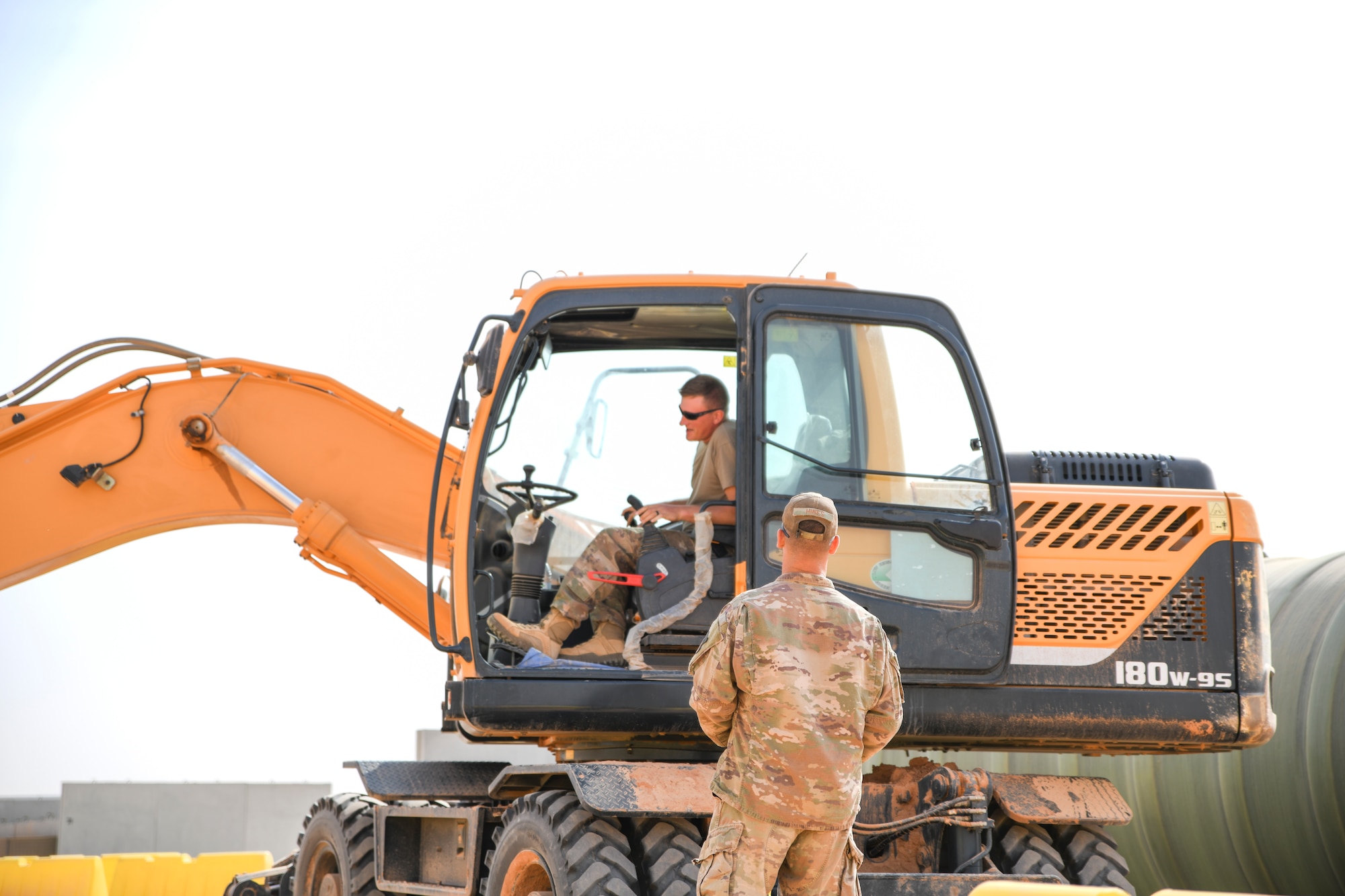 Prince Sultan Air Base, Kingdom of Saudi Arabia – U.S. Air Force Master Sgt. Marcus Hines discuss operations with Senior Airman Beaux Baur, 378th Expeditionary Civil Engineer Squadron engineers, during a construction project here, Dec. 14, 2019.