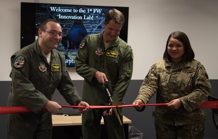 U.S. Air Force Col. David Lopez, 1st Fighter Wing commander, helps cut the ribbon at the opening ceremony of the innovation lab at Joint Base Langley-Eustis, Virginia, Dec. 17, 2019. The lab contains state-of-the-art equipment for Airmen to use. (U.S. Air Force photo by Airman 1st Class Sarah Dowe)