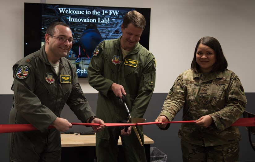 U.S. Air Force Col. David Lopez, 1st Fighter Wing commander, helps cut the ribbon at the opening ceremony of the innovation lab at Joint Base Langley-Eustis, Virginia, Dec. 17, 2019. The lab contains state-of-the-art equipment for Airmen to use. (U.S. Air Force photo by Airman 1st Class Sarah Dowe)