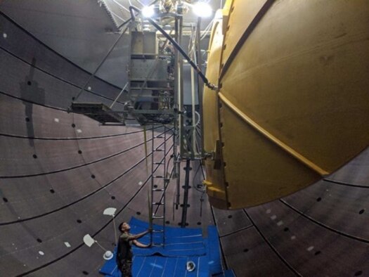 Image is a tethered aerostat radar system (TARS) device being optimized by personnel.