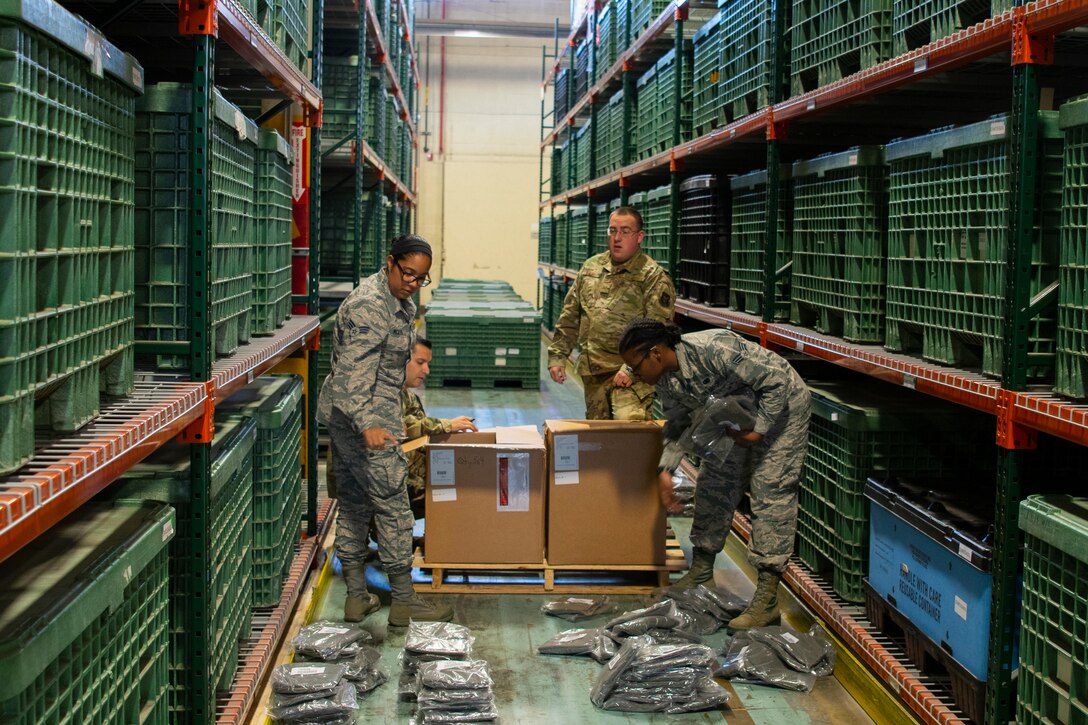 Photo of Airmen sorting cold weather parkas.