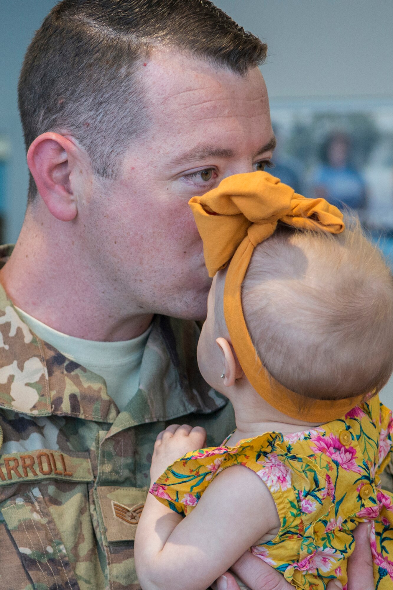 Photo of returning Airman kissing his child.