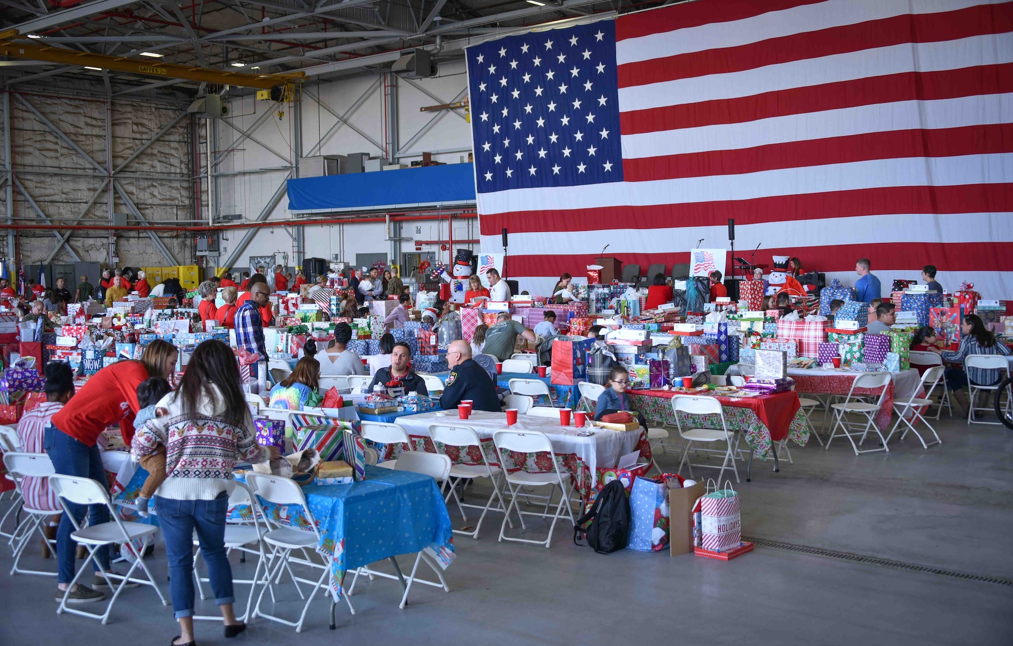 The 301st Fighter Wing, along with the Navy, Marines, Texas Air National Guard and Army came together to support the 5th Annual Holidays & Heroes event held for the first time on base at the VR-59 hangar, NAS Fort Worth JRB, Texas on Dec. 5, 2019. Approximately 150 volunteers came together to serve 75 military families (150 children and 130 adults) in need for holidays. (U.S. Air Force photo by Mr. Jeremy Roman)