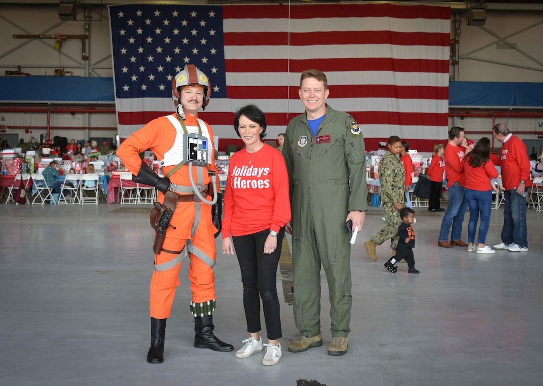 Capt. Skywalker, Kerre Randel Ortegel and 301st Fighter Wing Commander Col. Mitch Hanson stop for a second before the party officially started at the Holidays & Heroes event held for the first time on base at the VR-59 hangar, NAS Fort Worth JRB, Texas on Dec. 5, 2019. This holiday event, which was originated by 301 FW Security Forces Squadron Honorary Commander Mrs. Kerre Randel Ortegel and her husband Bob Ortegel five years ago. (U.S. Air Force photo by Mr. Jeremy Roman)