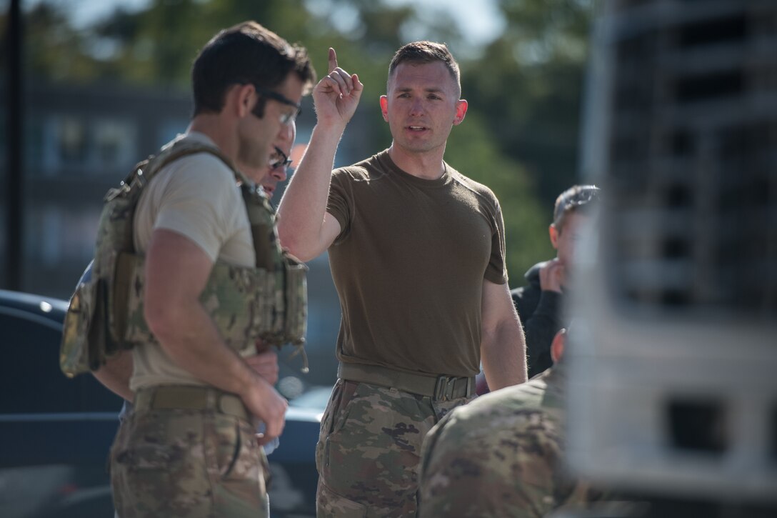 Staff Sgt. Bryan Meyer, 932nd Civil Engineer Squadron explosive ordnance disposal specialist, shares his observations with his team after assessing a bomb threat during a joint training scenario with the St. Louis Regional Bomb and Arson team in St. Louis, Oct. 22, 2019. Each team and had a chance to demonstrate their ability to respond to a simulated event. (U.S. Air Force photo by Christopher Parr)