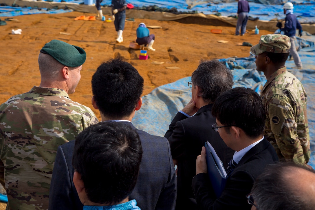 U. S. Army Garrison Okinawa Commander Lt. Col. Zachary B. Hohn shows Okinawa Governor Denny Tamaki an excavation site during a tour on Torii Station, Okinawa, Japan, Jan. 31, 2019. Historical artifacts dating back 10,000 years were discovered at this location. During the tour on Torii Station, members were shown plans to construct new buildings as part of the consolidation and relocation project. (U.S. Marine Corps photo by Lance Cpl. Nicole Rogge)