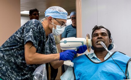 Hospital Corpsman Angel Vega takes an X-ray of a patient's mouth aboard USNS Mercy during Pacific Partnership 2018.