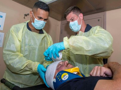 USNS Mercy Sailors treat simulated injuries on a patient during RIMPAC 2018.
