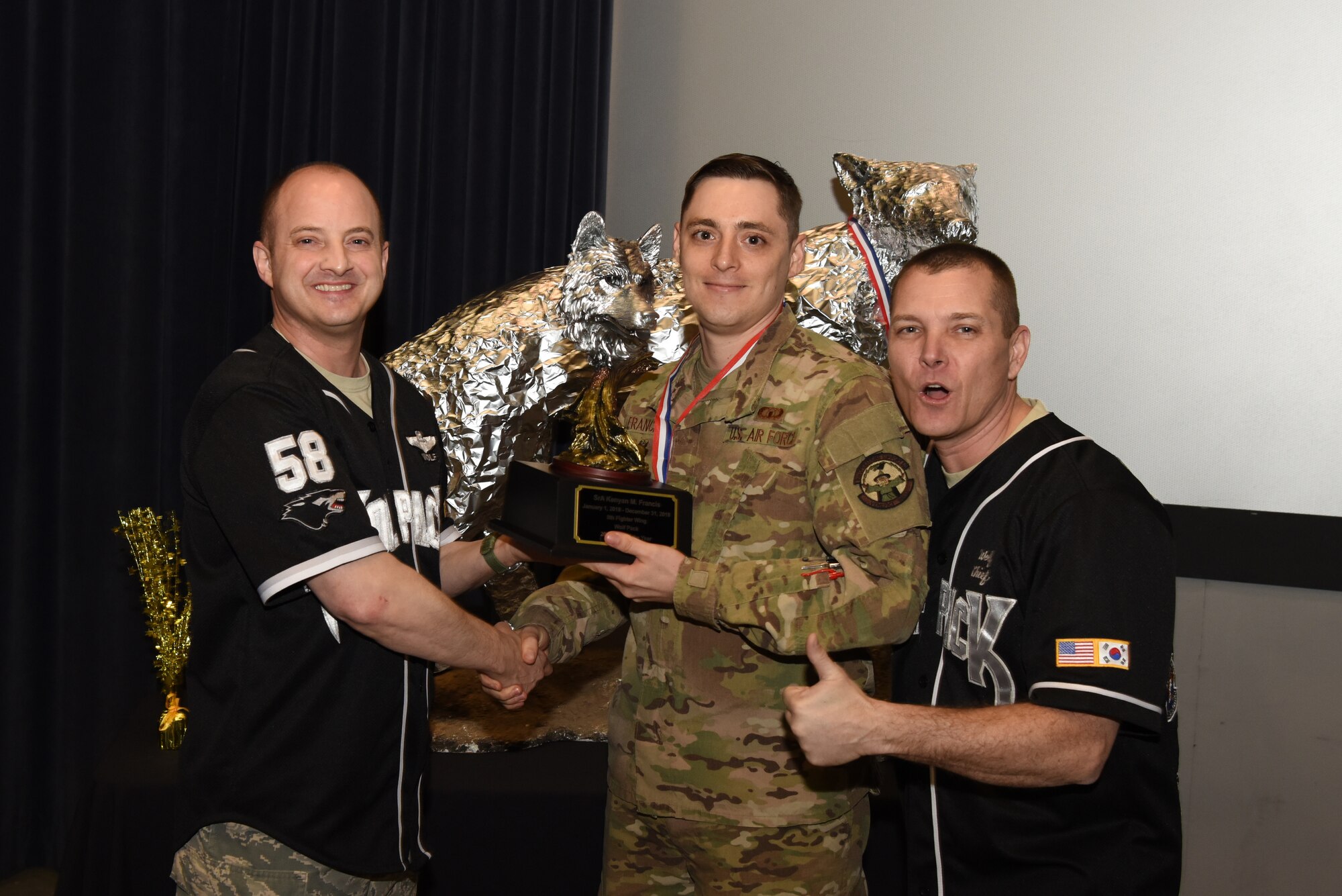 U.S. Air Force Col. John Bosone, 8th Fighter Wing commander, and Chief Master Sgt. Michael Moore Jr., 8th FW command chief, present the Airman of the Year to Senior Airman Kenyan Francis, 8th Operations Support Squadron, at Kunsan Air Base, Republic of Korea, Feb. 1, 2019. The Kunsan annual award winners will go on to compete at the 7th Air Force level. (U.S. Air Force photo by Staff Sgt. Joshua Edwards)