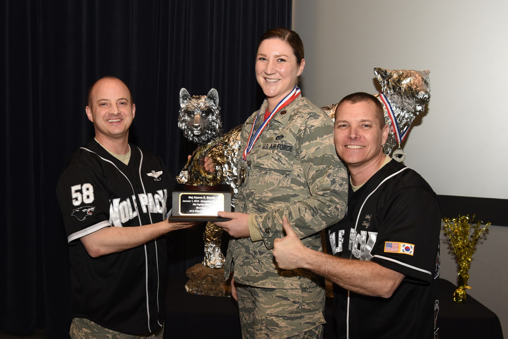 U.S. Air Force Col. John Bosone, 8th Fighter Wing commander, and Chief Master Sgt. Michael Moore Jr., 8th FW command chief, present the Flight Commander of the Year to Maj. Alyson Busch, 8th Civil Engineer Squadron, at Kunsan Air Base, Republic of Korea, Feb. 1, 2019. The Kunsan annual award winners will go on to compete at the 7th Air Force level. (U.S. Air Force photo by Staff Sgt. Joshua Edwards)