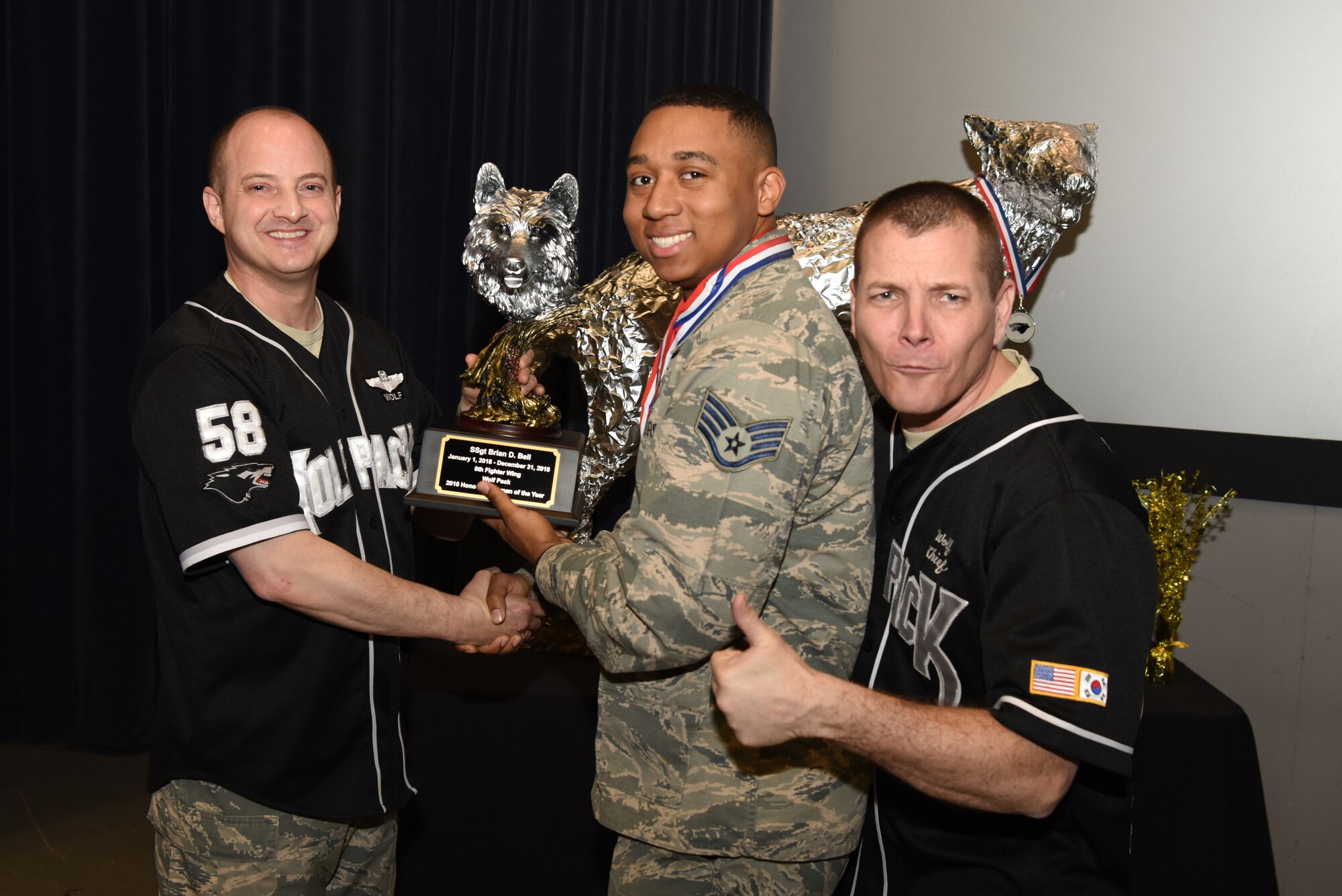 U.S. Air Force Col. John Bosone, 8th Fighter Wing commander, and Chief Master Sgt. Michael Moore Jr., 8th FW command chief, present the Honor Guard Airman of the Year to Staff Sgt. Brian Bell, 8th Logistics Readiness Squadron, at Kunsan Air Base, Republic of Korea, Feb. 1, 2019. The Kunsan annual award winners will go on to compete at the 7th Air Force level. (U.S. Air Force photo by Staff Sgt. Joshua Edwards)