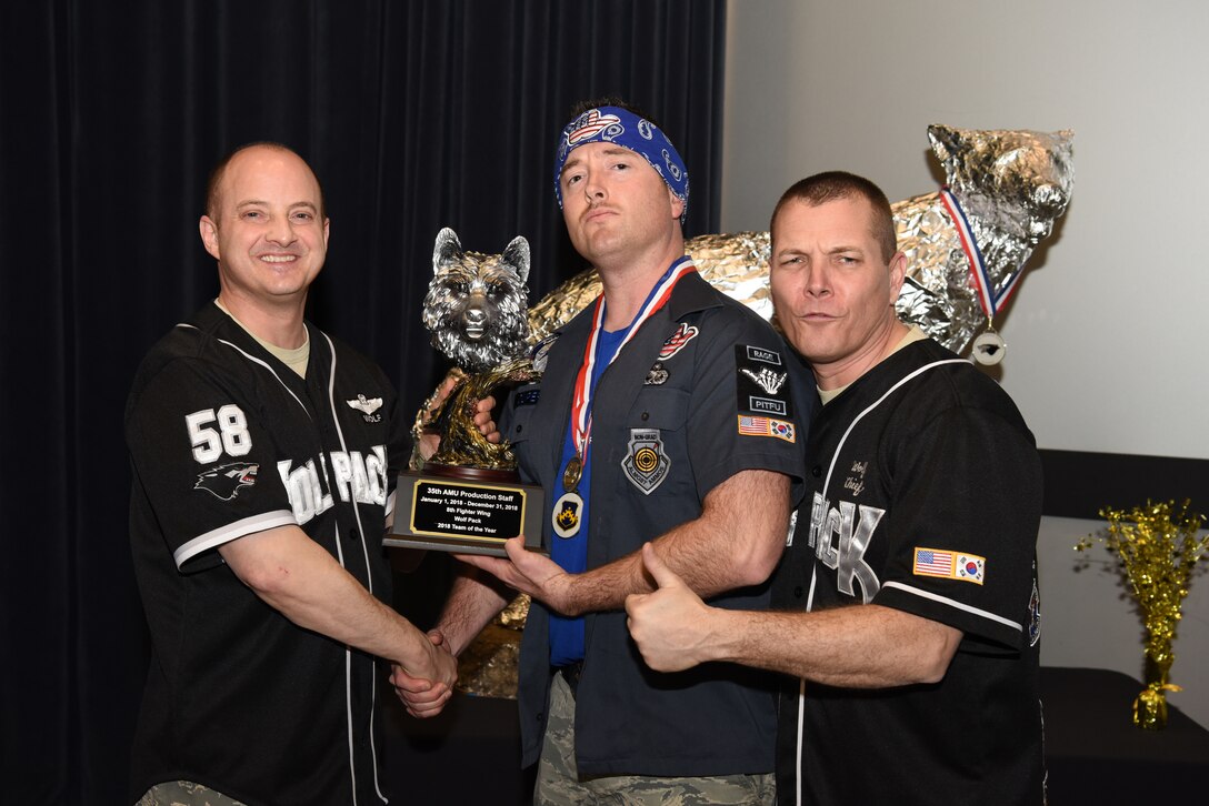 U.S. Air Force Col. John Bosone, 8th Fighter Wing commander, and Chief Master Sgt. Michael Moore Jr., 8th FW command chief, present the Team of the Year to a member of the 35th Aircraft Maintenance Unit Production Staff at Kunsan Air Base, Republic of Korea, Feb. 1, 2019. The Kunsan annual award winners will go on to compete at the 7th Air Force level. (U.S. Air Force photo by Staff Sgt. Joshua Edwards)