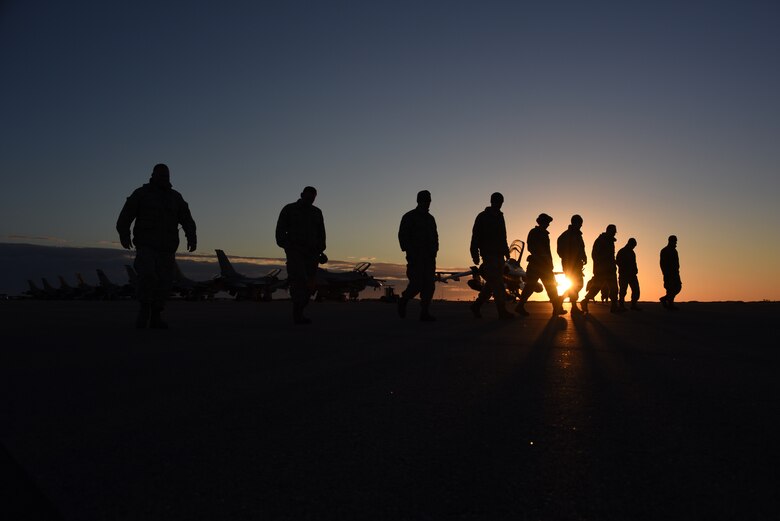 Airmen walk the flightline looking for debris